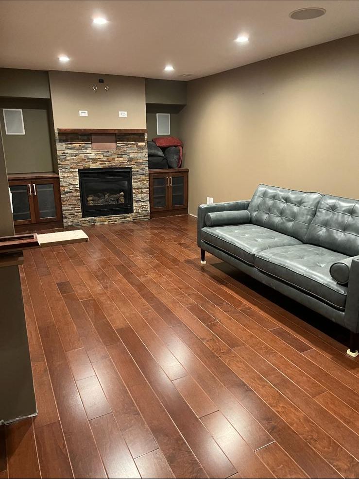Merlot hardwood basement lounge with stone fireplace