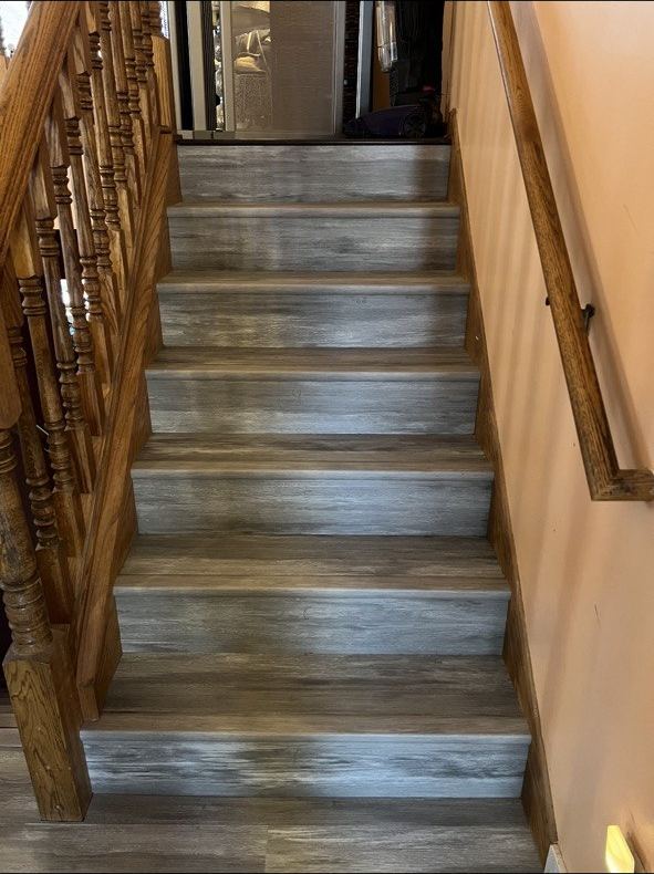 Gray LVP stairs with oak balustrade