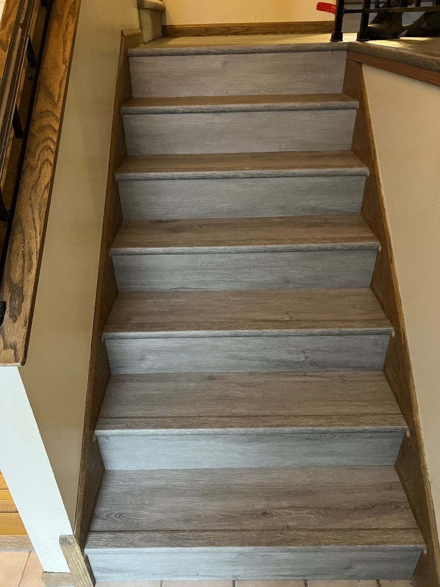 Gray LVP basement stairs with oak stringers
