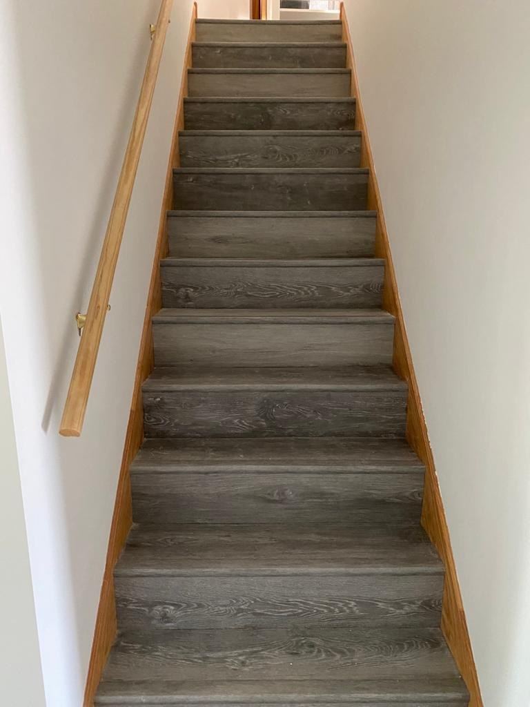 Gray LVP staircase with oak stringers