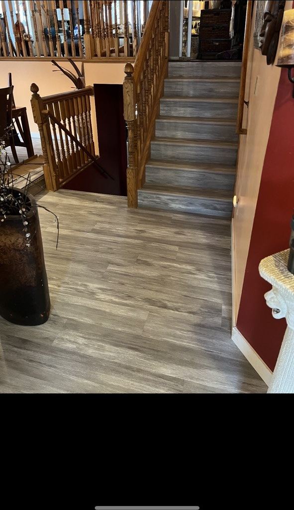 Gray LVP stairs with ornate oak railing
