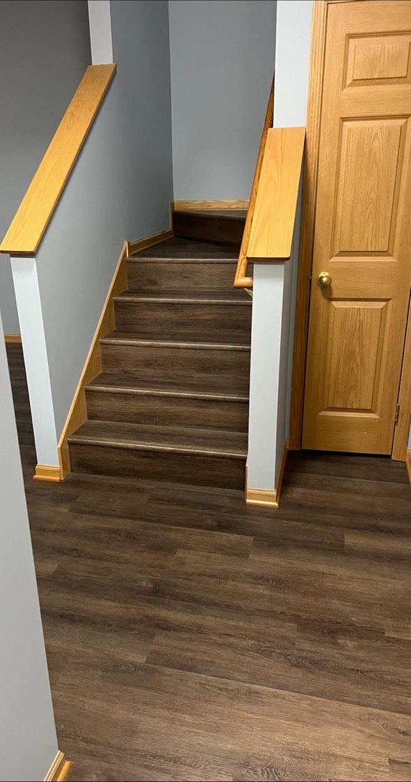 Dark LVP stairs with oak handrails